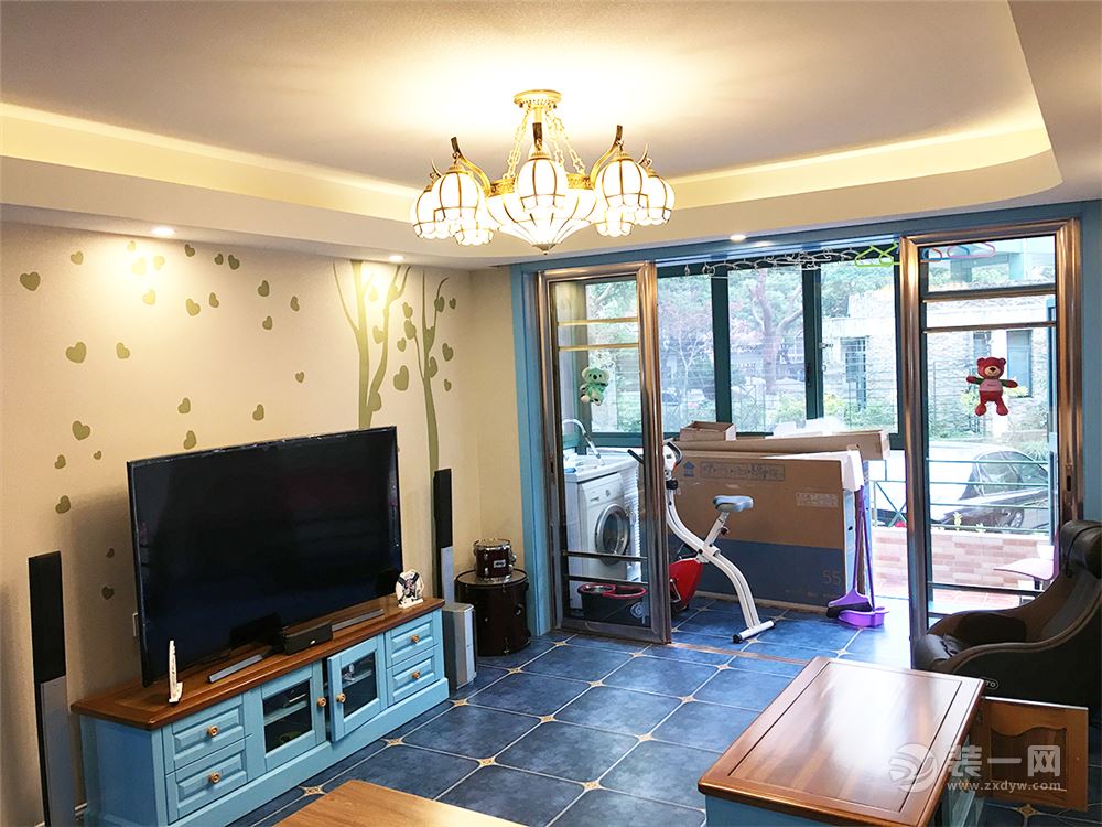 客厅的家具如茶几、电视柜，是由蓝色搭配原木系，两种色调强烈的撞击，异常大胆的撞色，海洋与深林的结合