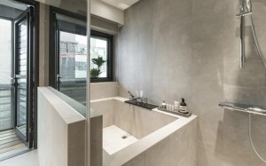 改造后的卫生间实现厕浴分离，利用黑色玻璃与木质隔断，划分厕浴界限。浴室灰白色瓷砖营造现代感，浴缸和淋