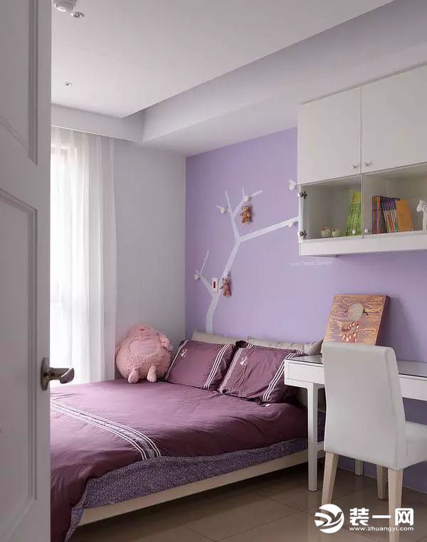 简单明亮的女儿房，床头墙面以浪漫的浅紫色搭配树枝图腾，上方的吊挂设计让小女孩得以展示心爱的玩偶，亦为