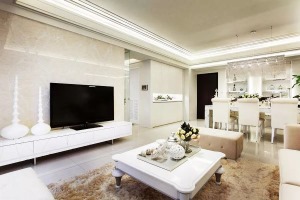以米白色大理石作为电视主墙，搭配纯白色低矮电视柜和桌面装饰，给人干净利落的感觉
