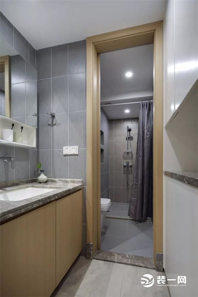 卫浴间也是以灰色瓷砖为主，在工艺方面都是以中心对称平铺的，对称的美感让空间显得更宽敞。