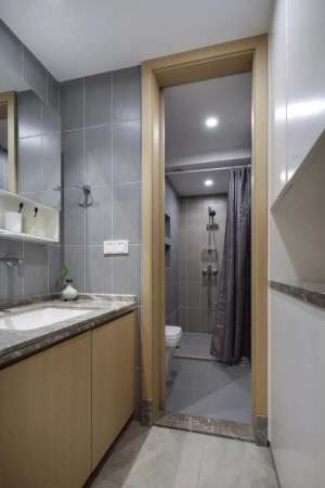 卫浴间也是以灰色瓷砖为主，在工艺方面都是以中心对称平铺的，对称的美感让空间显得更宽敞。