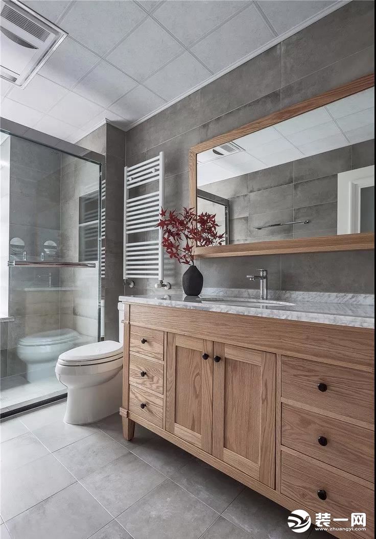  卫生间铺贴浅灰色仿古砖，质朴典雅。淋浴间采用了透明玻璃的隔断，给人纯净自然的舒适感