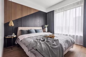  主卧，木质的床头背景墙，以一道斜纹划分出木与黑的界限，带来一个简约时尚的空间。