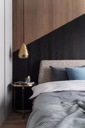  床头边几上方垂落一盏金色的吊灯，注入一份优雅的气质感。