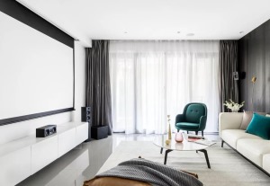 客厅一张圆形的大理石茶几，墨绿色的抱枕与沙发椅，一席米白色地毯与布艺沙发，打造了现代优雅的空间