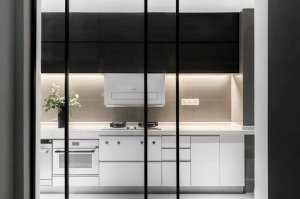 厨房设计了白色的橱柜+黑色的吊柜，吊柜做了藏光的设计，在强烈的色彩对比下更凸显层次感