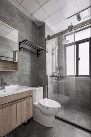  深灰调的卫生间，镜面柜与浴室柜底部都有留空，方便储物。