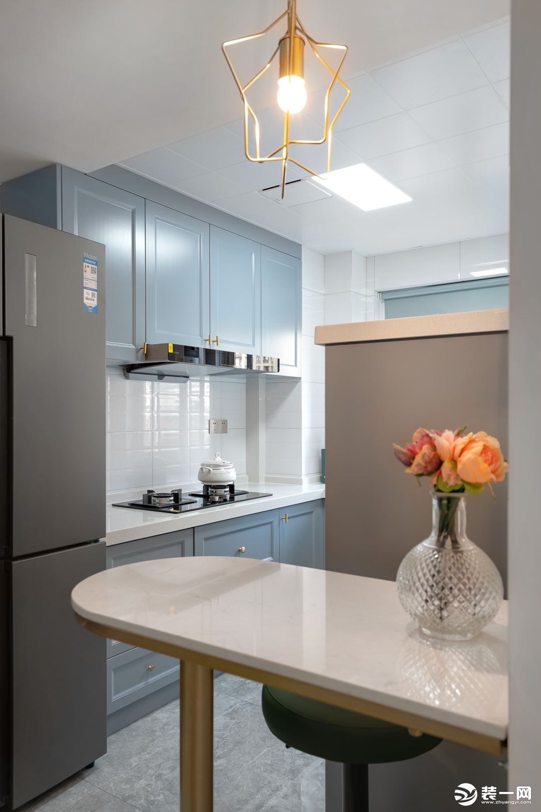 厨房空间采用开放式形式，浅蓝色柜体搭配白色瓷砖，