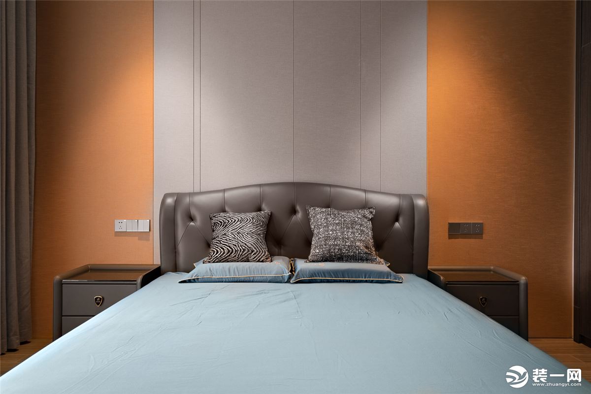 床头背景墙做了灰色硬包，嵌入线条，既有效拉伸空间层次感，也与爱马仕橙色的墙面，形成时髦的撞色效果。