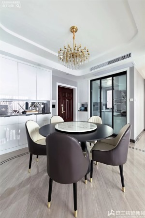 餐厅选用黑白两色搭配的双层餐桌，餐桌椅的造型简洁、圆润，金属的餐椅包角从细节上呼应了轻奢的调性