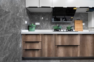 灰色墙砖搭配木色柜体，稳重大气，上下双层的柜体也让厨房收纳变得更加从容。