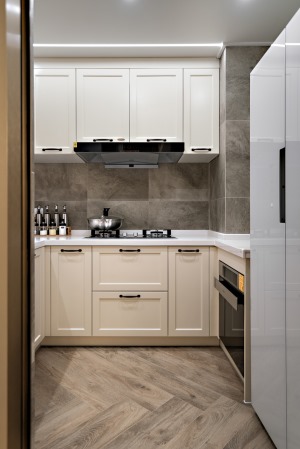 白色柜体搭配灰色瓷砖，简约时尚。上下双层的柜体设计，也让小空间厨房的收纳变得更为从容。