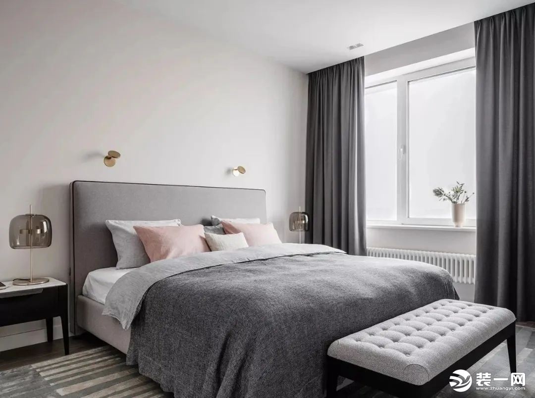 卧室空间中，设计师依旧延续整体的设计风格，营造出了一个适合休憩的平静的灰色区域。来自不同品牌的软装家