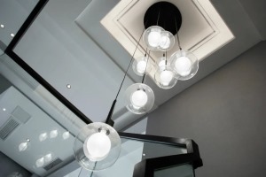樓梯頂部裝上高低不一的球形吊燈，讓整個樓梯間都有均勻明亮的光線，避免了照明不均勻導致的底部樓梯昏暗