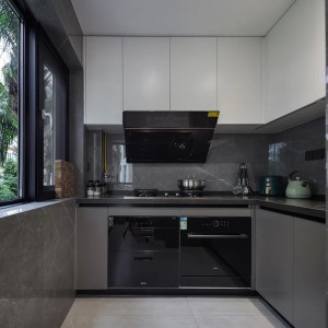 厨房以深灰色的墙面砖+橱柜设计，L字形的操作台为主人提供了一个方便宽松的烹饪空间，做饭有了轻松舒适的