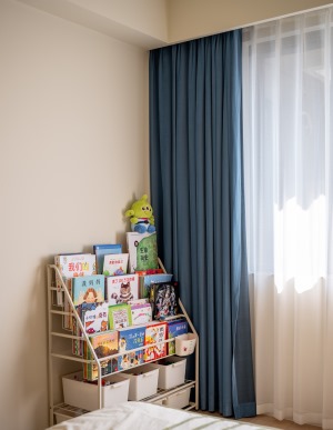 搭配男孩子都喜欢的蓝色作窗帘，添加朴拙可爱的童趣。窗边做简单的阅读、学习区，方便以后跟随孩子的成长做