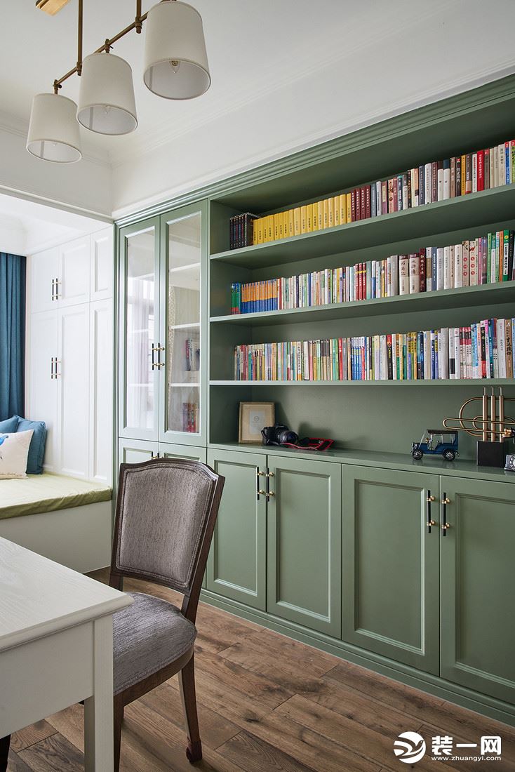 书房，灰绿色书柜作为局部点缀，给阅读空间增加静谧质感。靠窗设置榻榻米，工作的间隙也能放松休憩。