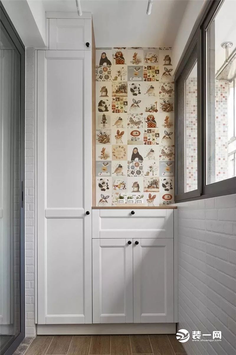客厅外的阳台一侧摆放洗衣机和洗手台，在柜子当中留出一部分卡通图案的花砖，显得更有文艺感。