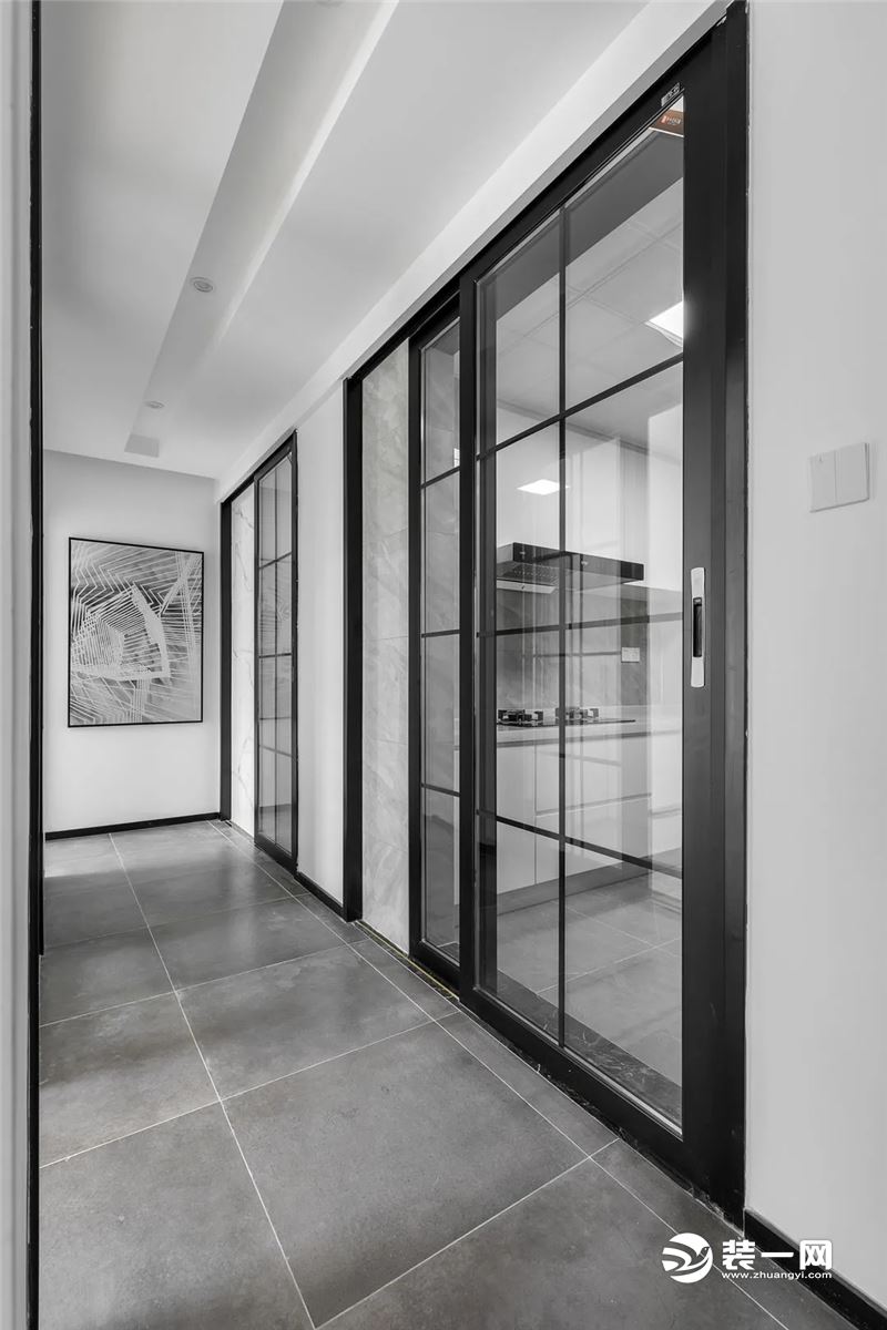 狭长的走廊空间，两侧的屋门全部选择了黑框玻璃门，解决了走廊昏暗无光的问题。