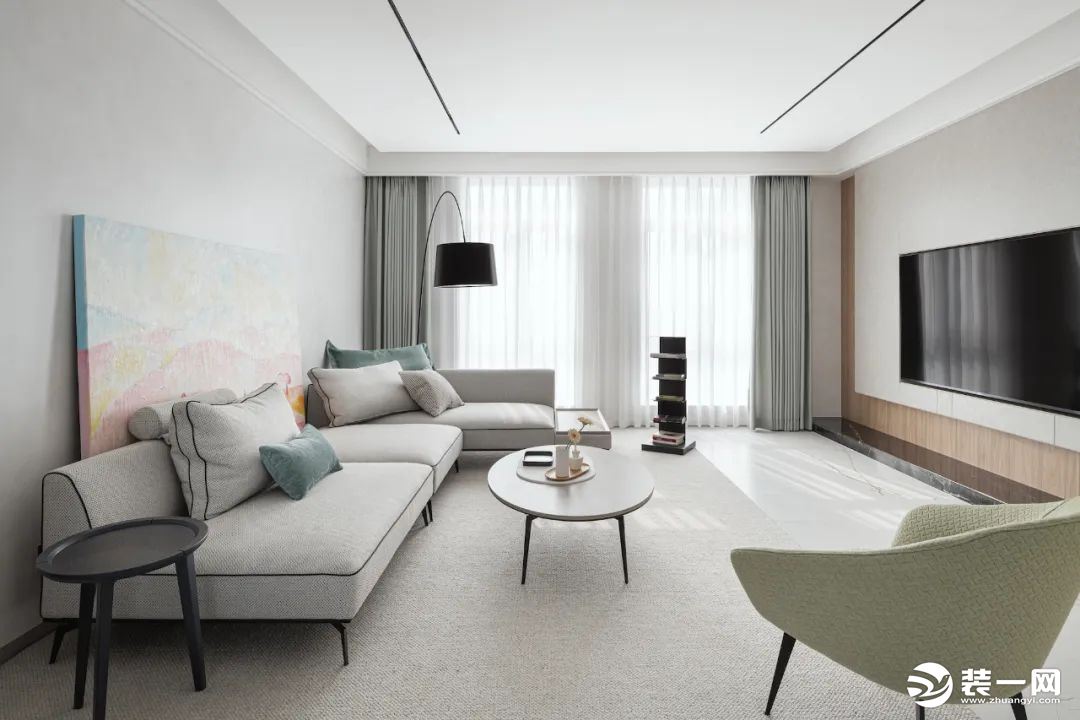 客厅色调上整体暖白，局部点缀浅绿色，沙发后方一幅淡雅的抽象画，整体空间优雅又不失格调。