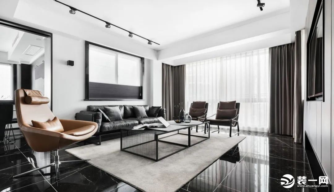 灰色主沙发中和墙面的白与地面的黑。边上的两张深咖色边椅又呼应米咖色的地毯。