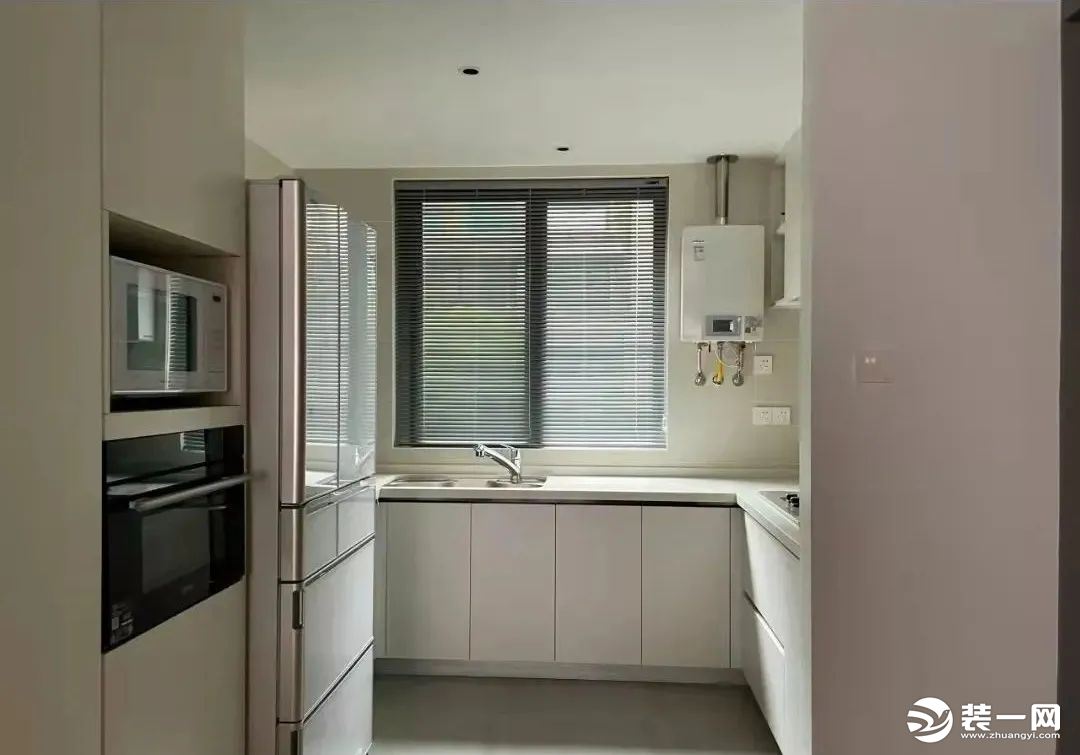 将原来的厨房空间外扩，形成开放式厨房，电器高柜与冰箱并列分布在厨房一侧，一体化的白色橱柜轻盈而实用。
