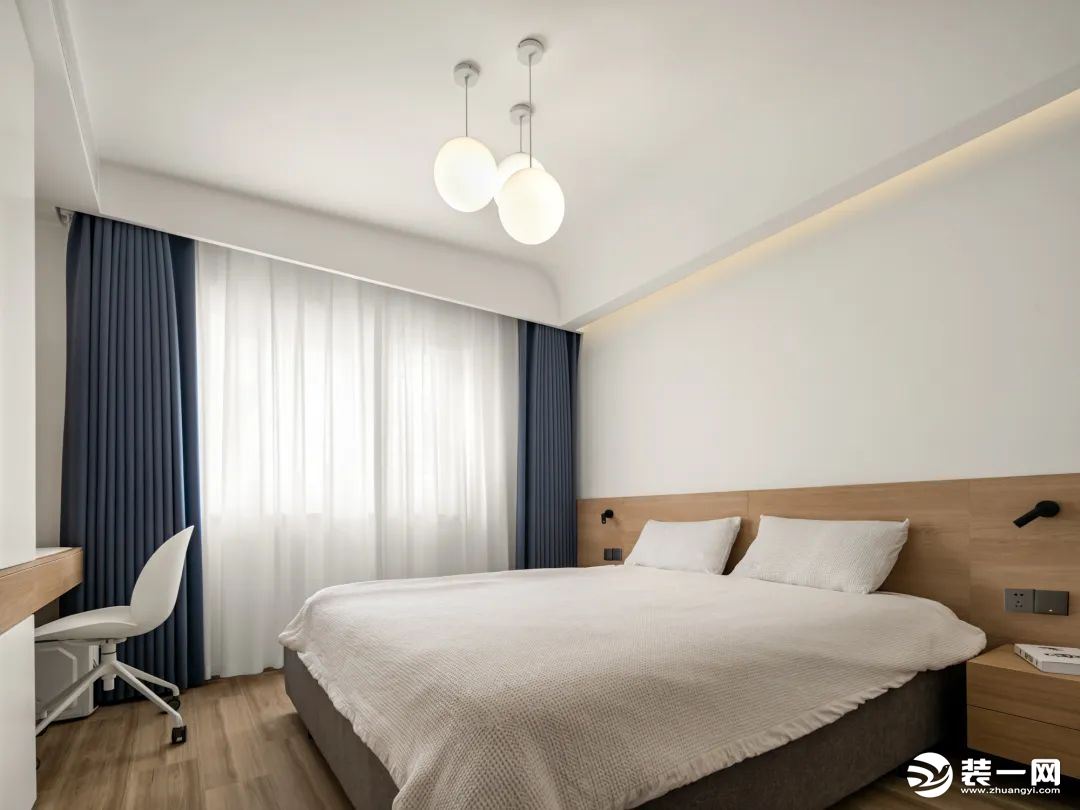 次卧则明亮温暖许多，白色的床品和木色的床柜，让人感觉简约而又自然。