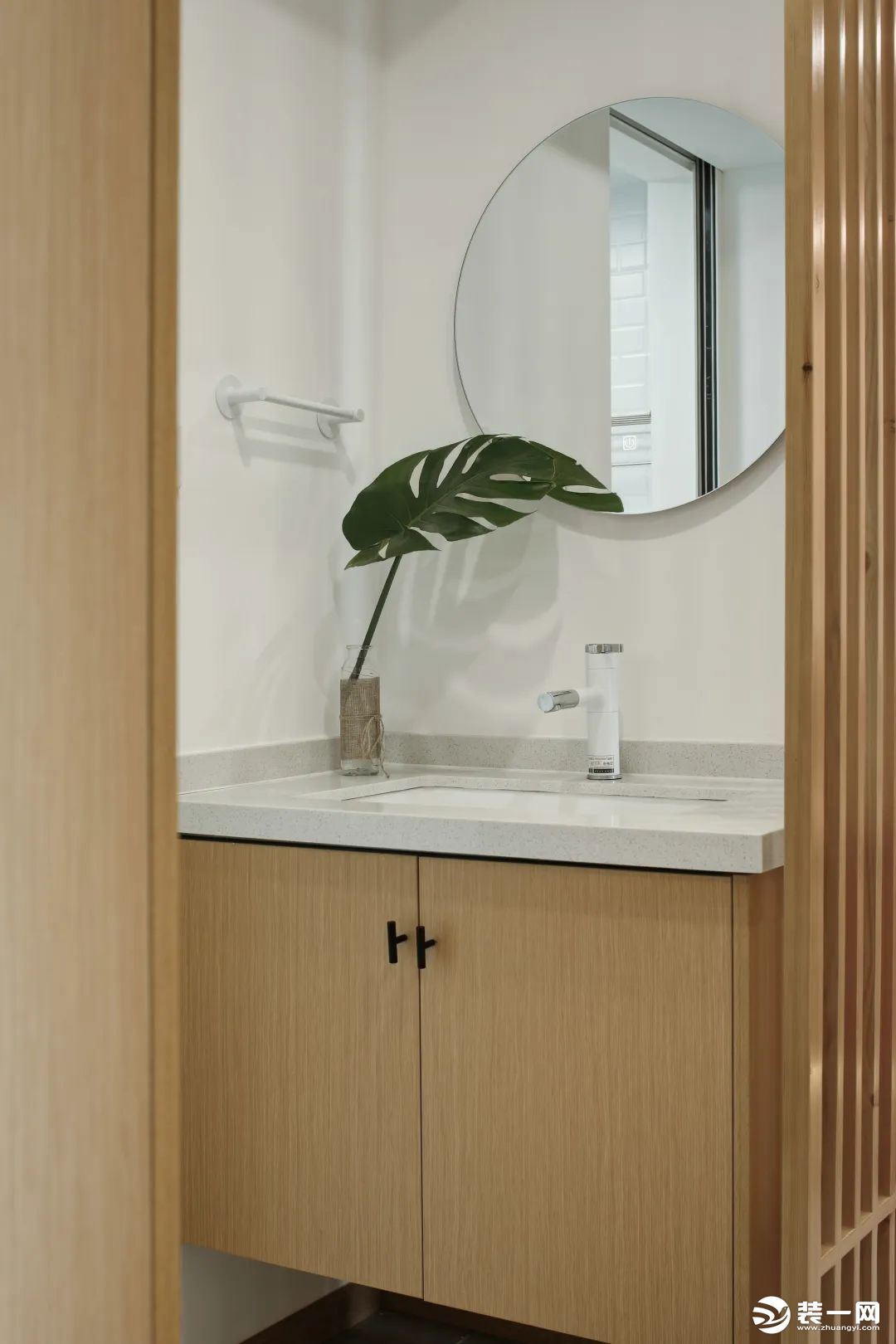卫生间采用白色和浅木色搭配，看起来温暖又简约，一抹绿植瞬间点亮空间，渲染了生机感。