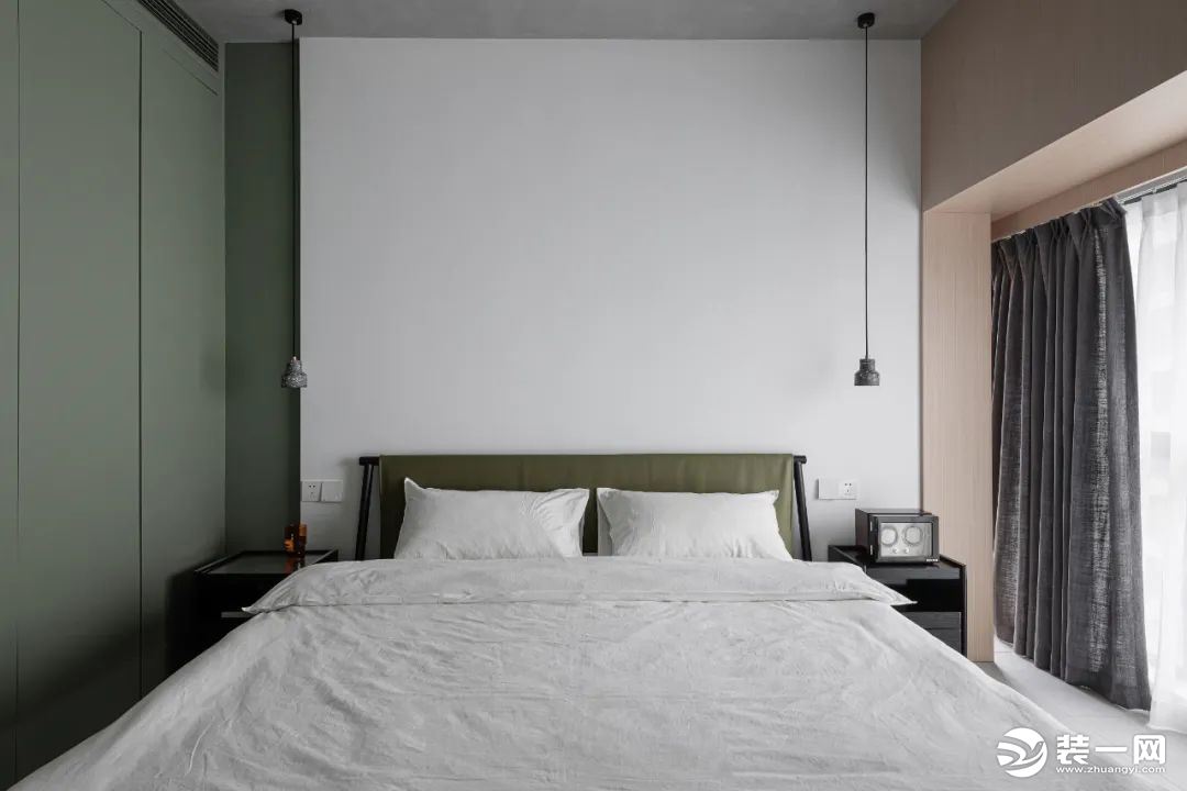 卧室的色彩上使用了沉稳灰调绿，床头大面积的留白处理，窗户几面的原木饰面板的装饰，避免了空间的单调。
