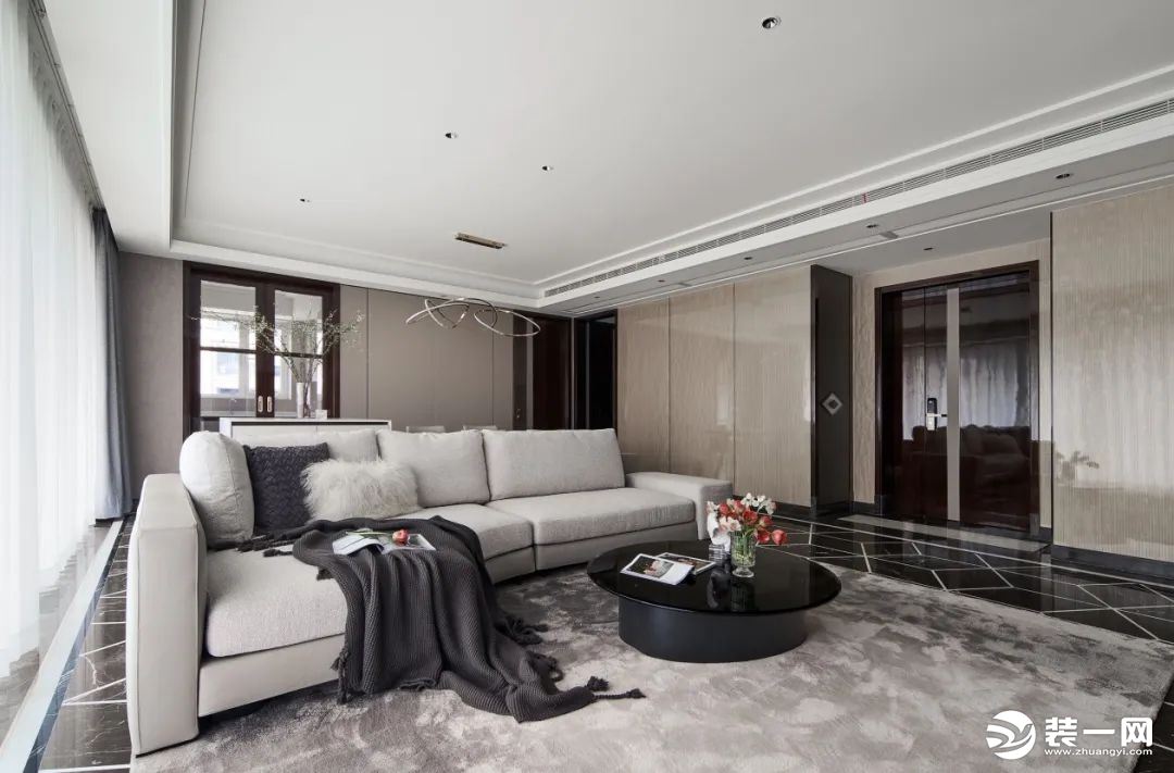 客厅选用低饱和度的米灰色系的沙发与原本的浅色墙面相呼应，整体色调和谐一致。