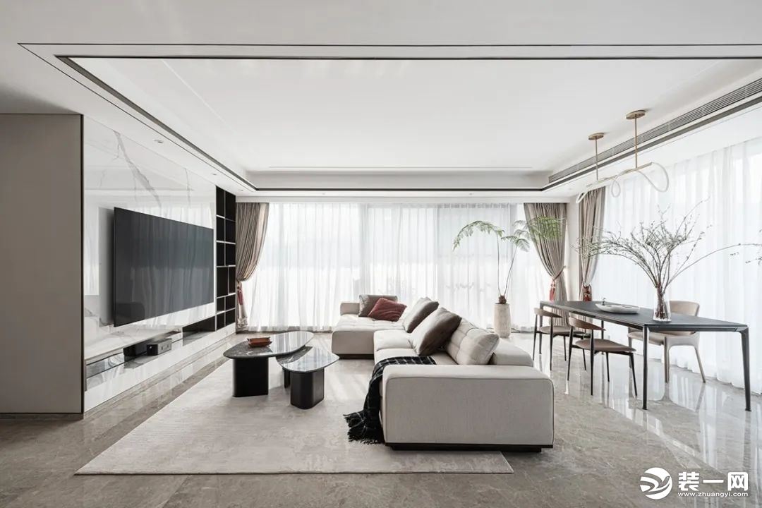 客厅以低饱和度的色调贯穿整个空间，舒缓柔雅，布艺米白色沙发搭配浅色的地毯，展现出和谐统一的空间质感。