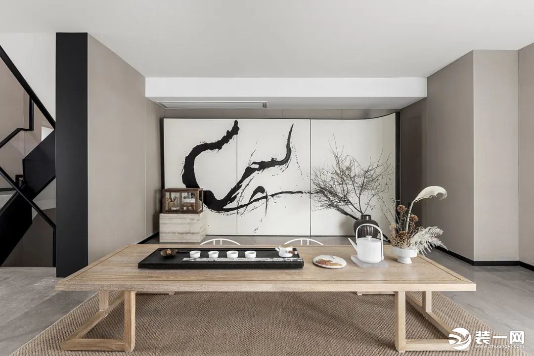 茶室以创意性毛笔画为背景墙，灵动脱俗，原木的茶桌和枯木干枝搭配在一起，新中式的禅意之美，油然而生。