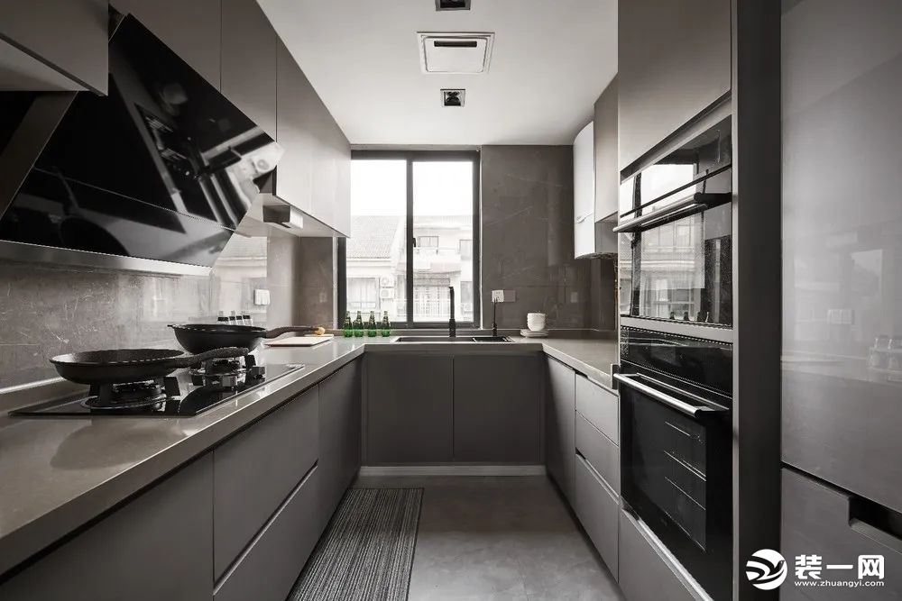 厨房U字形的操作台，暖灰色的定制橱柜与墙面地面砖，让做饭空间也显得实用现代而时尚端庄。