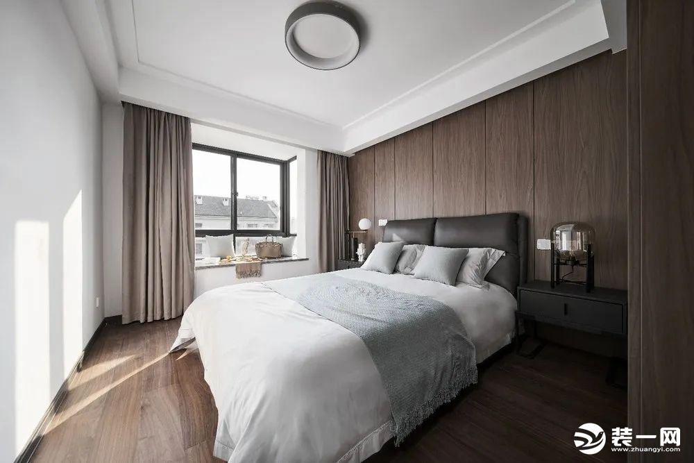 卧室床头墙以木饰面为背景，床头墙的木饰面与木地板保持一致的木纹色调，营造出现代舒适而自然的卧室氛围。