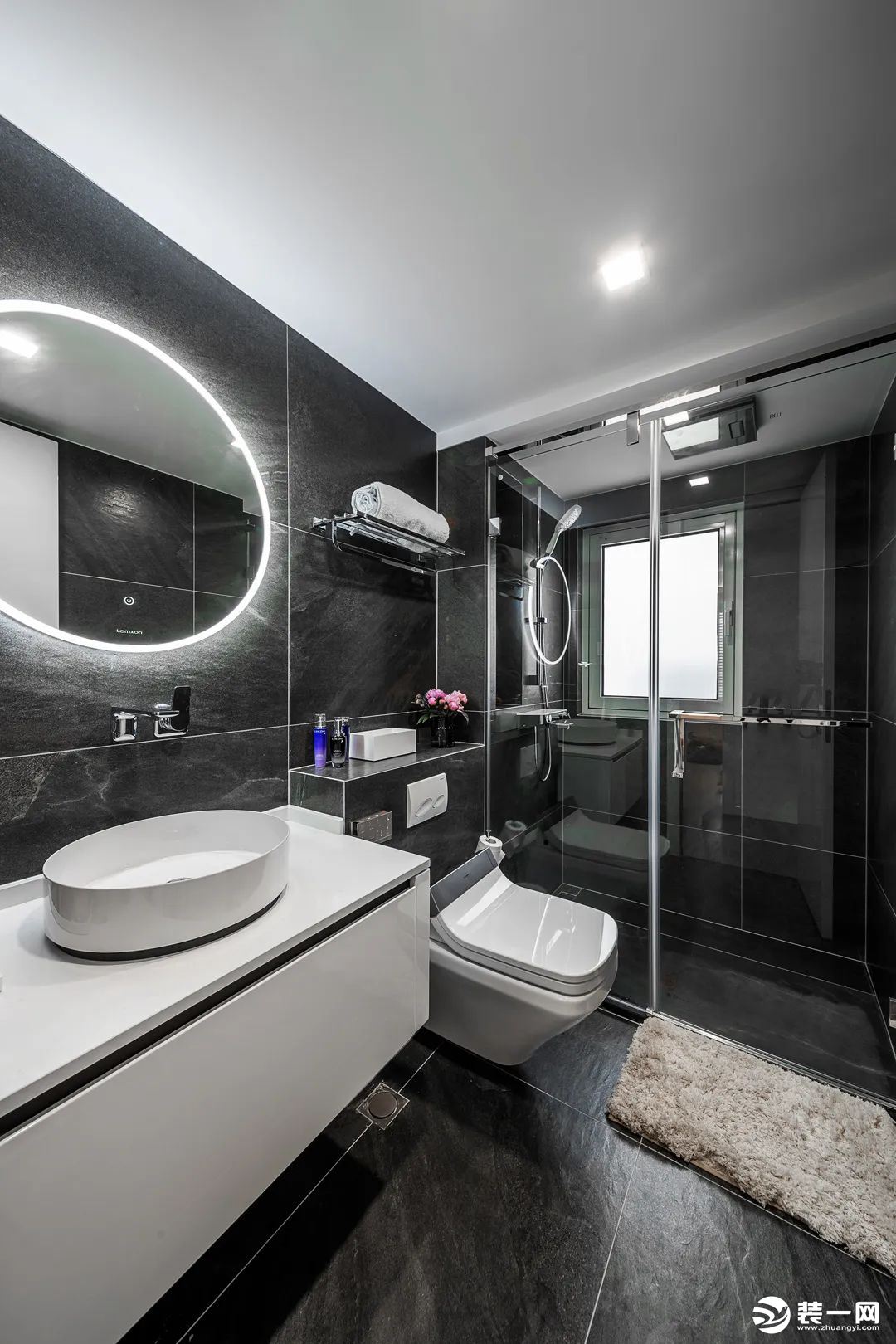 卫生间采用的是干湿分离的设计，通长的洗面台设计使整个空间更加整体，深灰色瓷砖和纯白色洗手台形成对比。