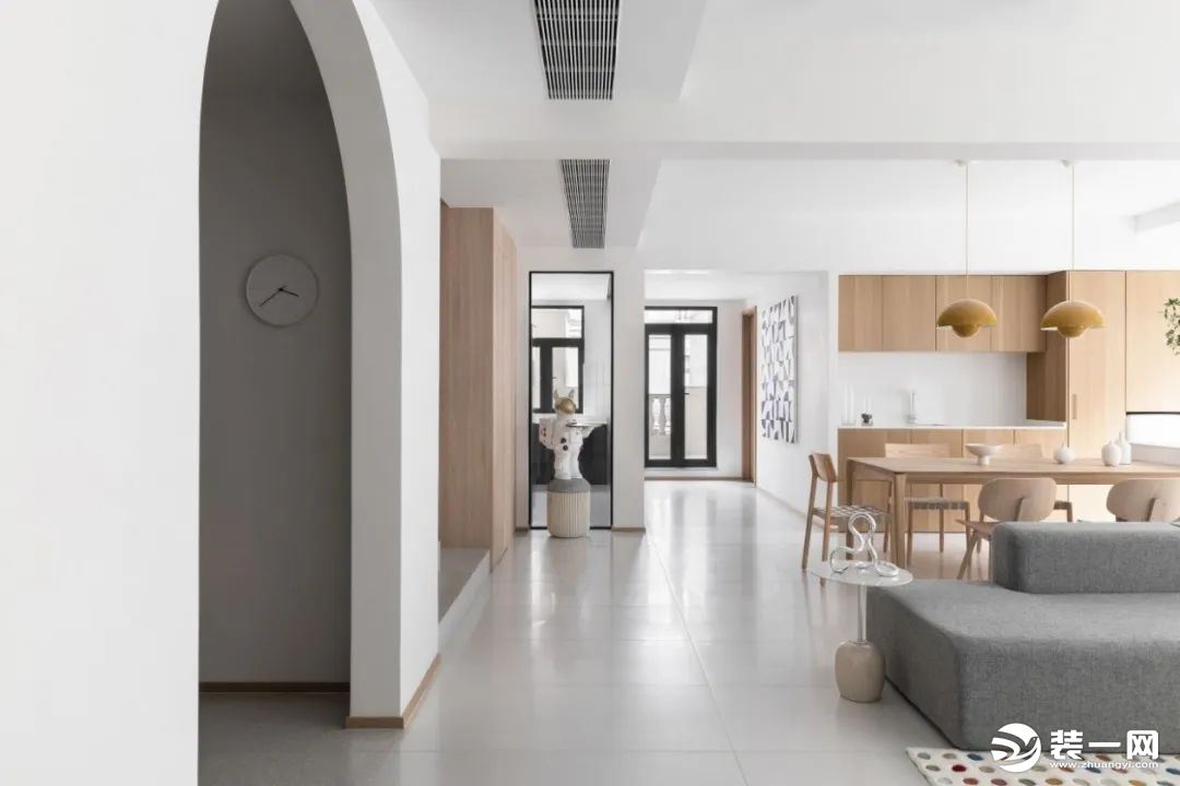 设计师选用白色与浅灰色作为主色调，辅以木质家具，奠定了静谧优雅的空间氛围。