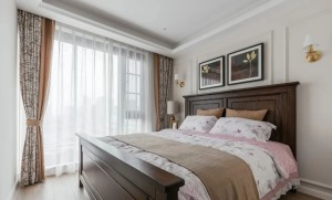 次卧，大面落地窗提供充足采光，古典美式的木质大床与挂画相得益彰