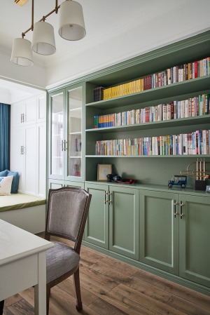 书房，灰绿色书柜作为局部点缀，给阅读空间增加静谧质感。靠窗设置榻榻米，工作的间隙也能放松休憩。