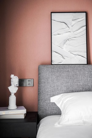 次卧，灰色布艺大床与砖粉色床头背景平衡着空间的刚柔美感。