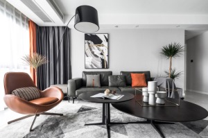 黑色皮质沙发简约而舒适，高亮度的爱马仕橙，注入了整个黑白灰的空间里，减少了沉闷感，增加了时尚感。