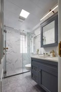卫生间灰色地砖搭配白色大理石墙砖，再加上蓝灰色的浴室柜，让卫生间在简洁的基础上，多出了华丽优雅感。
