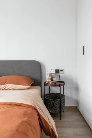 暖色调的床品温馨舒适，与实木地板、白色衣柜营造北欧风情。