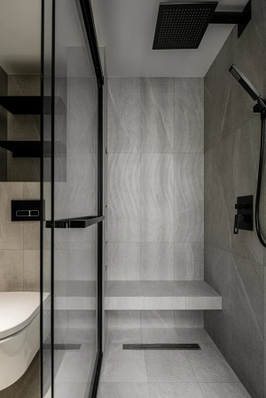 卫生间，黑色五金件搭配灰色系列的瓷砖，高级感十足。空间被分割成三个区块，洗漱、马桶、淋浴间互不干扰。