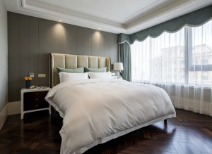 主卧以简单、舒适为主题，灰色的背景墙配上清淡温和色系床品，营造出宁静平和的休憩环境。