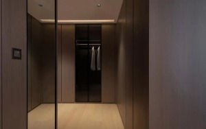 主卧更衣室里虚实相间的柜体，正面镜子掩映着卧室空间，无形之中两个空间仿佛在对话。