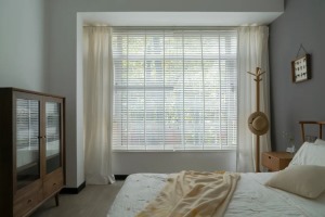 卧室柜子、衣架等木质元素自然且舒适，百叶窗与棉布窗帘结合，窗外景色虚虚实实。