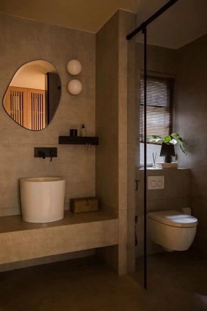 淋浴间设置在靠浴缸一侧，在淋浴间隔墙上开了圆形窗洞，与天井景观对望，打破空间的区隔，让沐浴变得愉悦。
