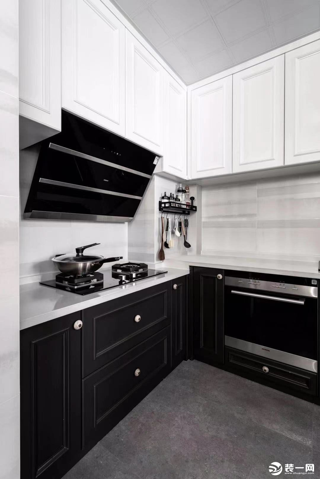 以黑白为主调的厨房尽显空间极致高级感，功能上，集中厨、水吧为一体；细节上，高低台设计在不经意间给予下