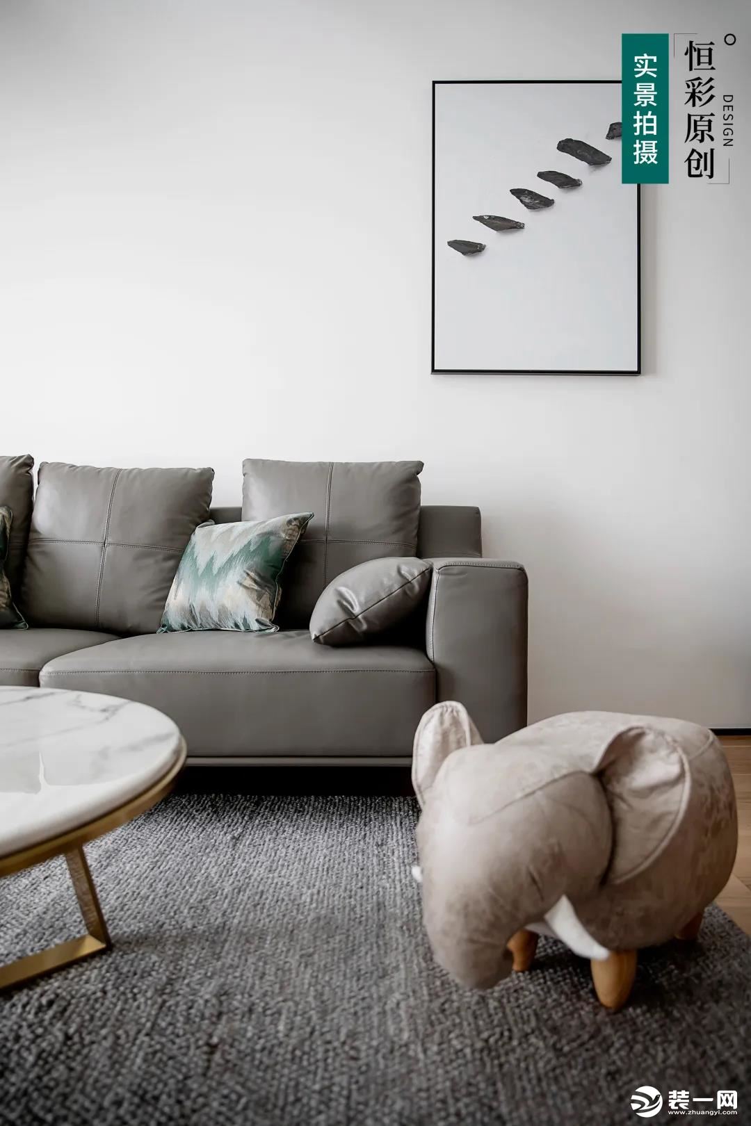 深空灰色皮质沙发，搭配大面积大白墙，简单干净。